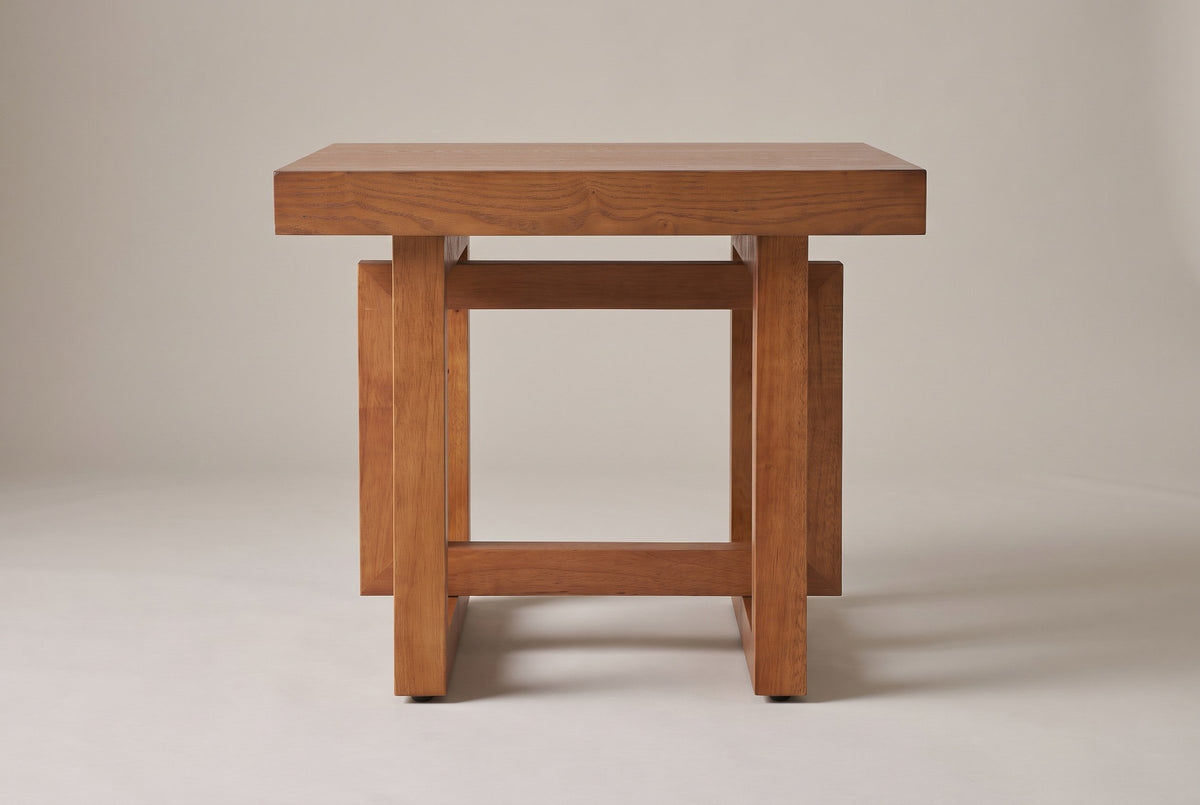 Soave side table in walnut, straight front view: thick square top, two posts, an upper and a lower rail