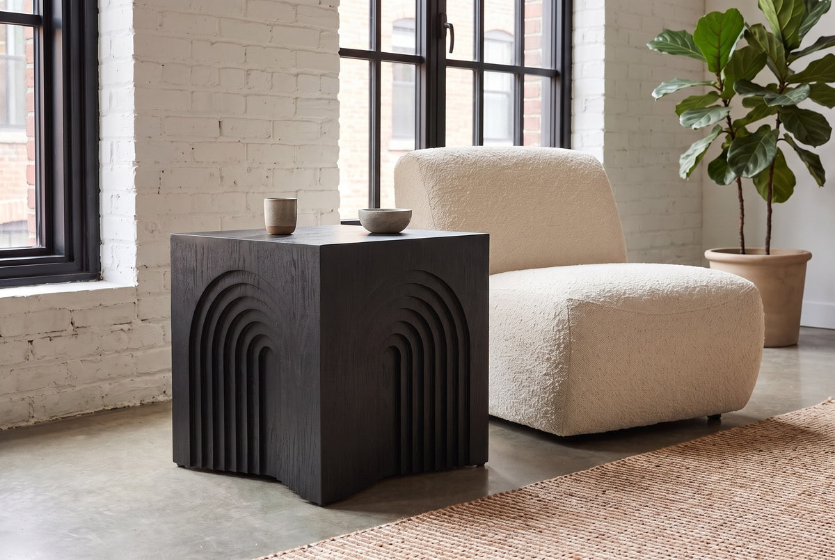 Sondrio side table in Black beside a cream boucle chair in a Montreal loft with whitewashed brick
