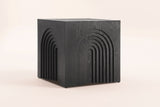 Sondrio cube side table in Black, three-quarter view on a warm grey studio backdrop