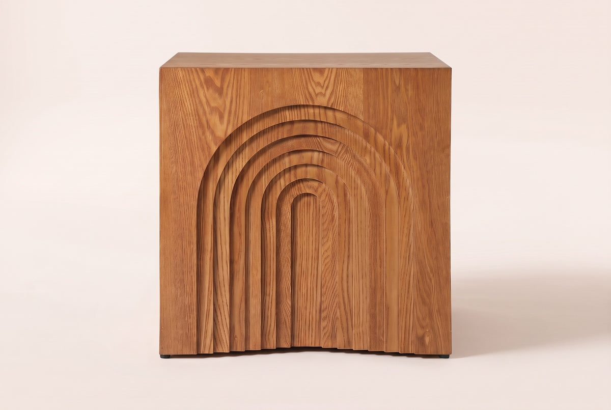 Sondrio side table, straight front view: a stepped arch of seven nested arches carved into the side