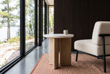 Sorano side table beside a cream boucle lounge chair in a Minaki house on the Winnipeg River, with dark oak panelling