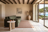 Sorano side table at the end of an olive linen sofa in an island house on Pantelleria, with sand lime plaster