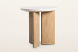 Sorano side table at eye level on a warm white studio backdrop: the round terrazzo top and the oak slab legs with a gap betwe