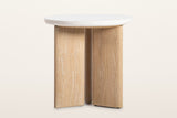 Sorano side table on a warm white studio backdrop, turned to show the three oak slabs meeting under the top like a pinwheel