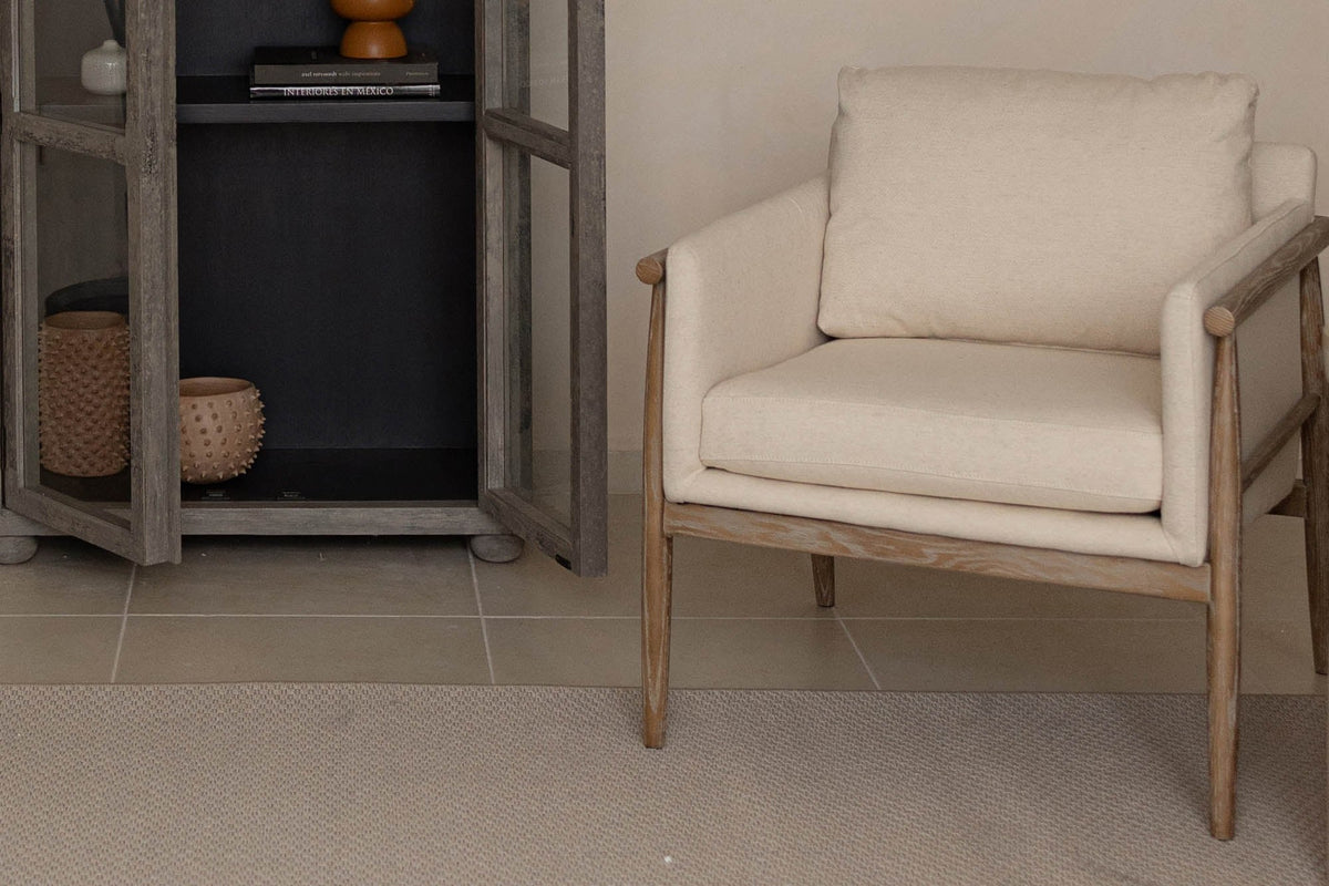 Soren accent chair with beige cushions and an exposed ash frame in a living room corner