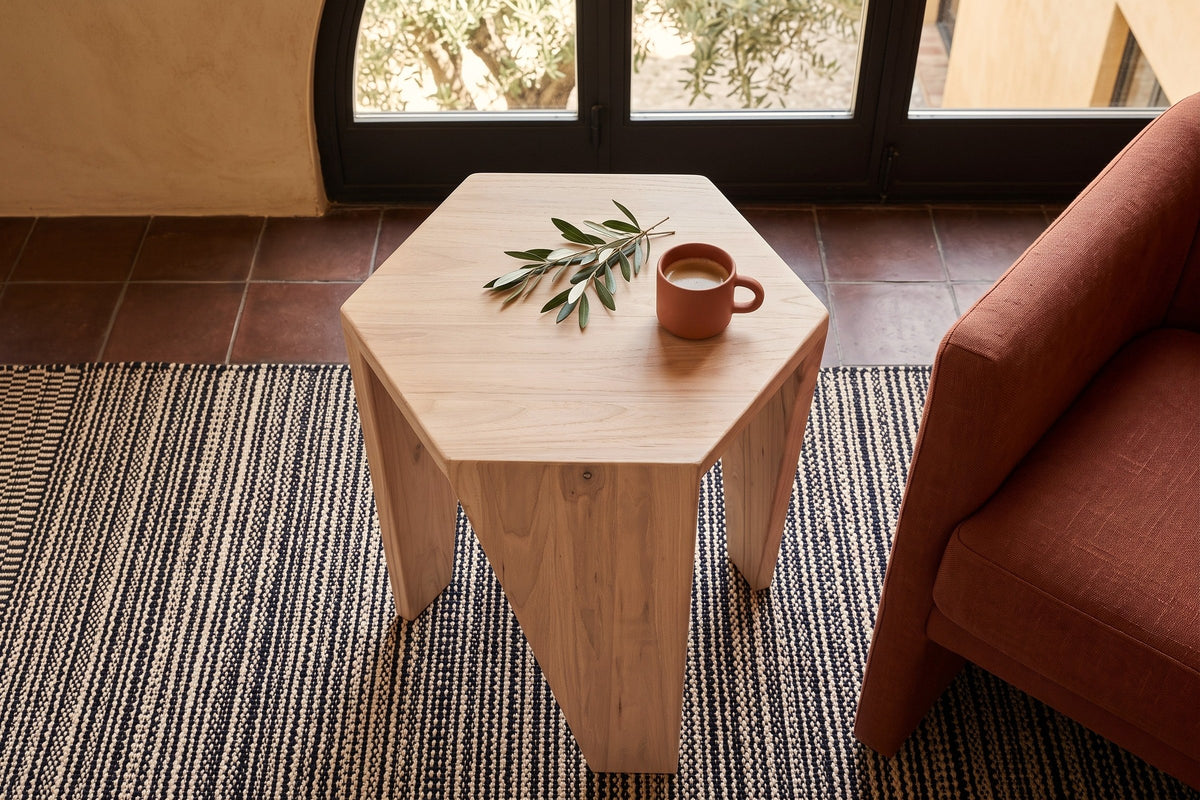 Sovana side table in Sandblast White Elm seen from above beside a rust linen lounge chair in a courtyard house