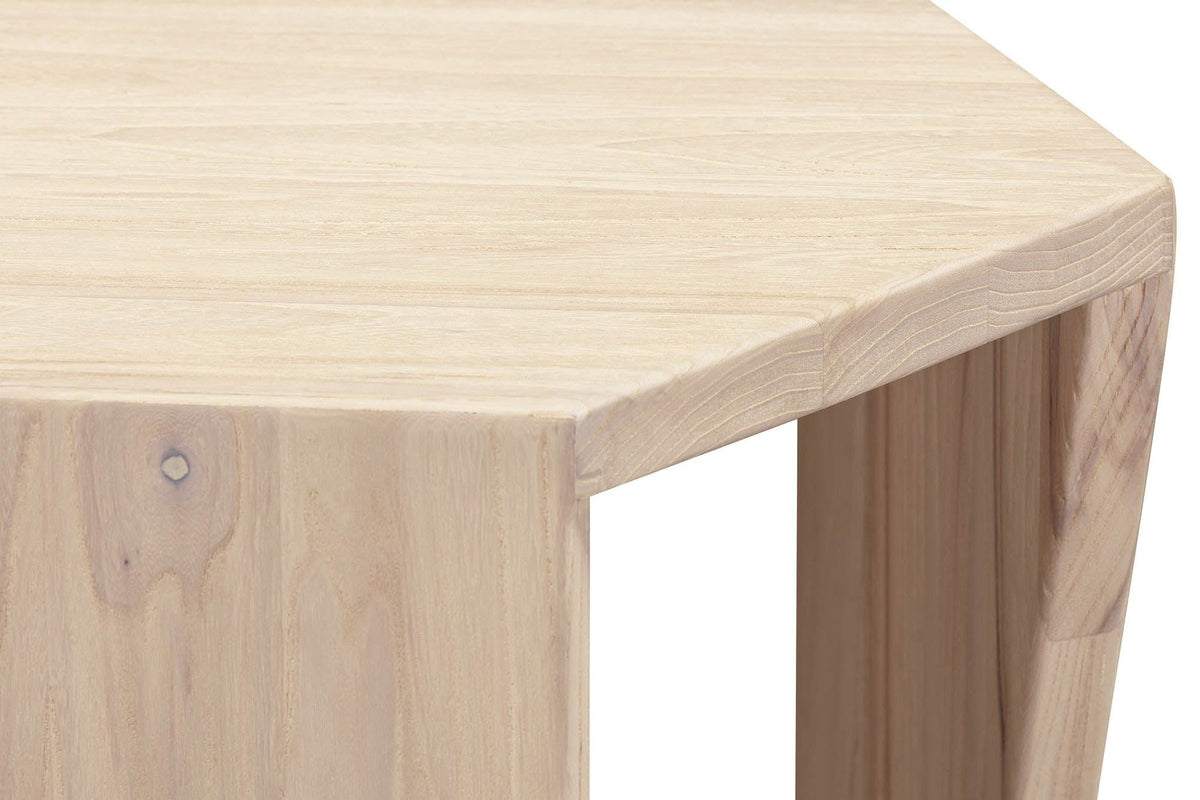 Close-up of a Sovana leg in Sandblast White Elm under a corner of the top: flowing elm grain and a small filled knot