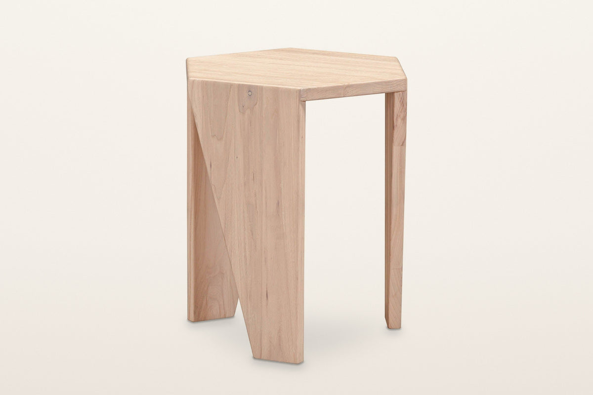 Sovana elm side table in Sandblast White Elm, three-quarter view on a warm white studio backdrop: a hexagon top on folded wed
