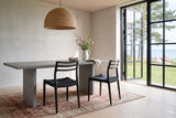 Two Sperlinga dining chairs in black seen from behind at a grey limestone table in a Bornholm island house