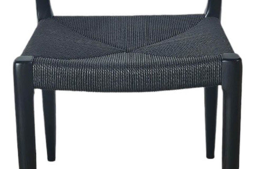 Close-up of the black paper cord seat of the Sperlinga chair, woven four ways and wrapped over the front rail
