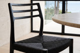 Close-up of the Sperlinga seat and back in black: the four-way cord weave, the front leg caps and the three back rails