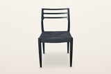 Sperlinga dining chair in black, front view on a warm white studio backdrop