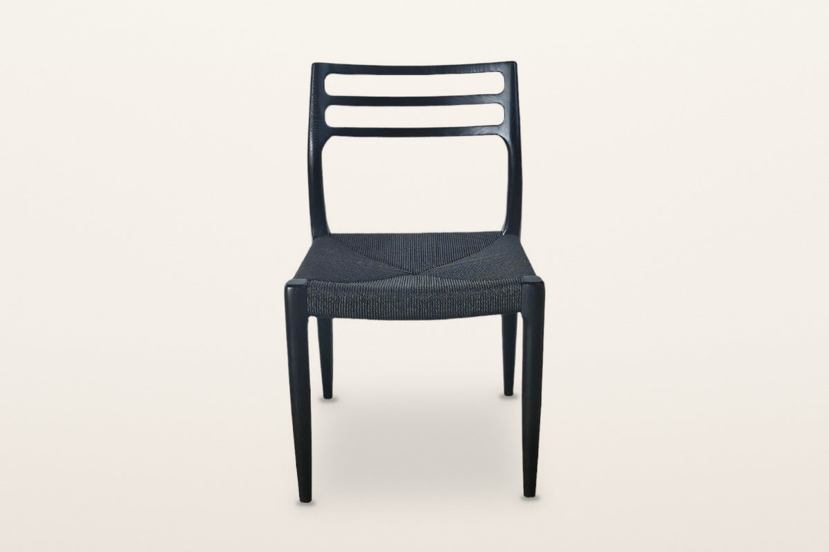 Sperlinga dining chair in black, front view on a warm white studio backdrop