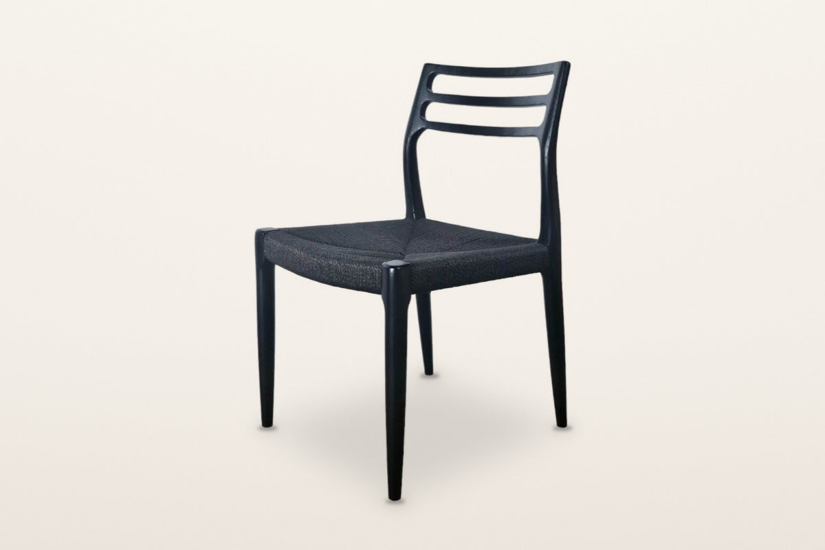Sperlinga dining chair in black, three-quarter view on a warm white studio backdrop: three curved back rails