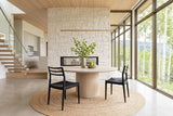Two Sperlinga dining chairs in black at a round limed-oak table in a Sun Peaks mountain house, with a pale stone wall