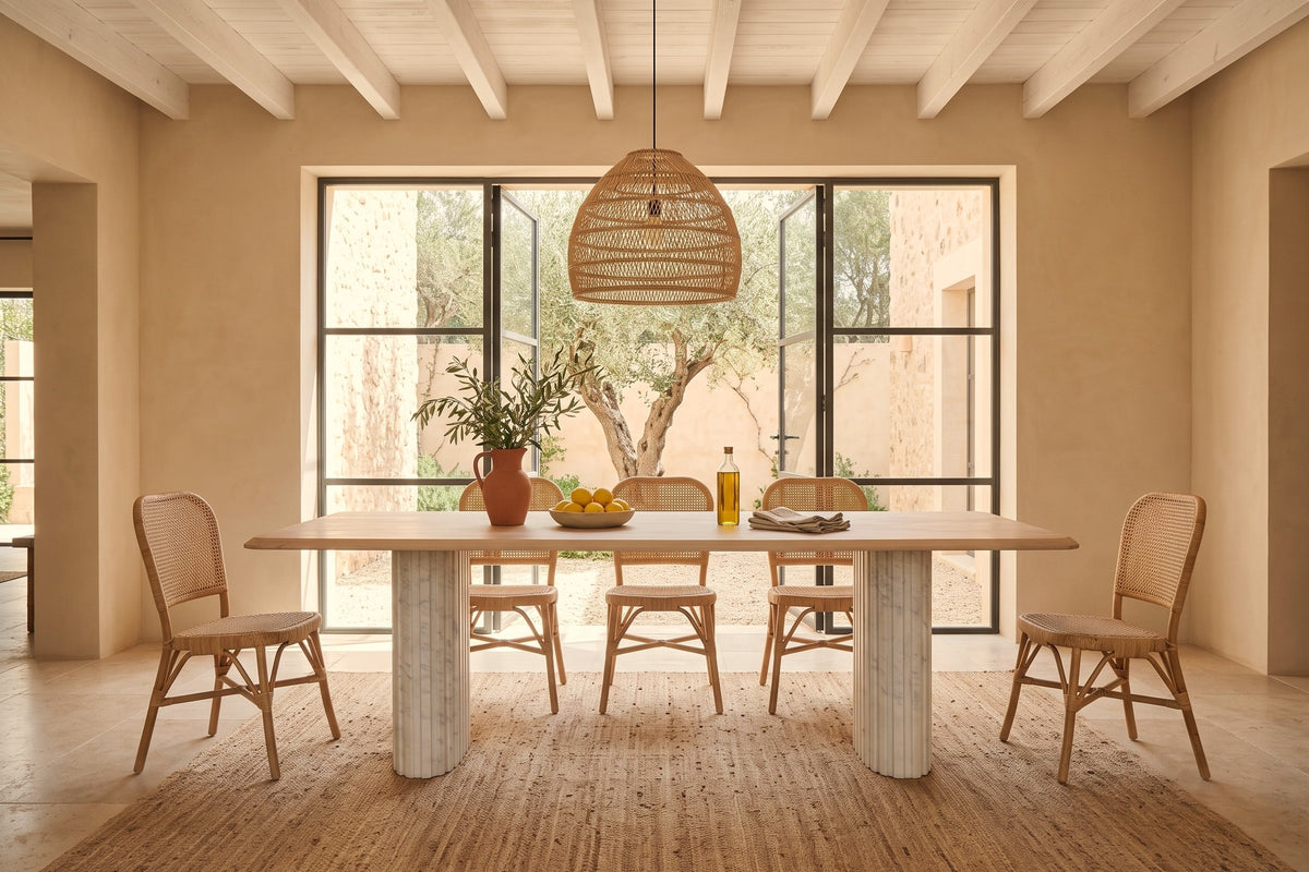 Staffolo dining table in Natural in a Mallorca courtyard villa with sand limewash walls, whitewashed beams and rattan chairs