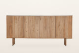 Staffolo sideboard in Natural, straight front view on a warm white studio backdrop: four equal reeded doors under a thin whit