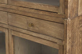 Close-up of a Suvereto drawer in Smokey Grey with its small square gold-finish knob, under a glass door frame