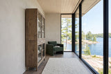 Suvereto display cabinet in Smokey Grey seen from the side along a greige wall in a Stoney Lake cottage