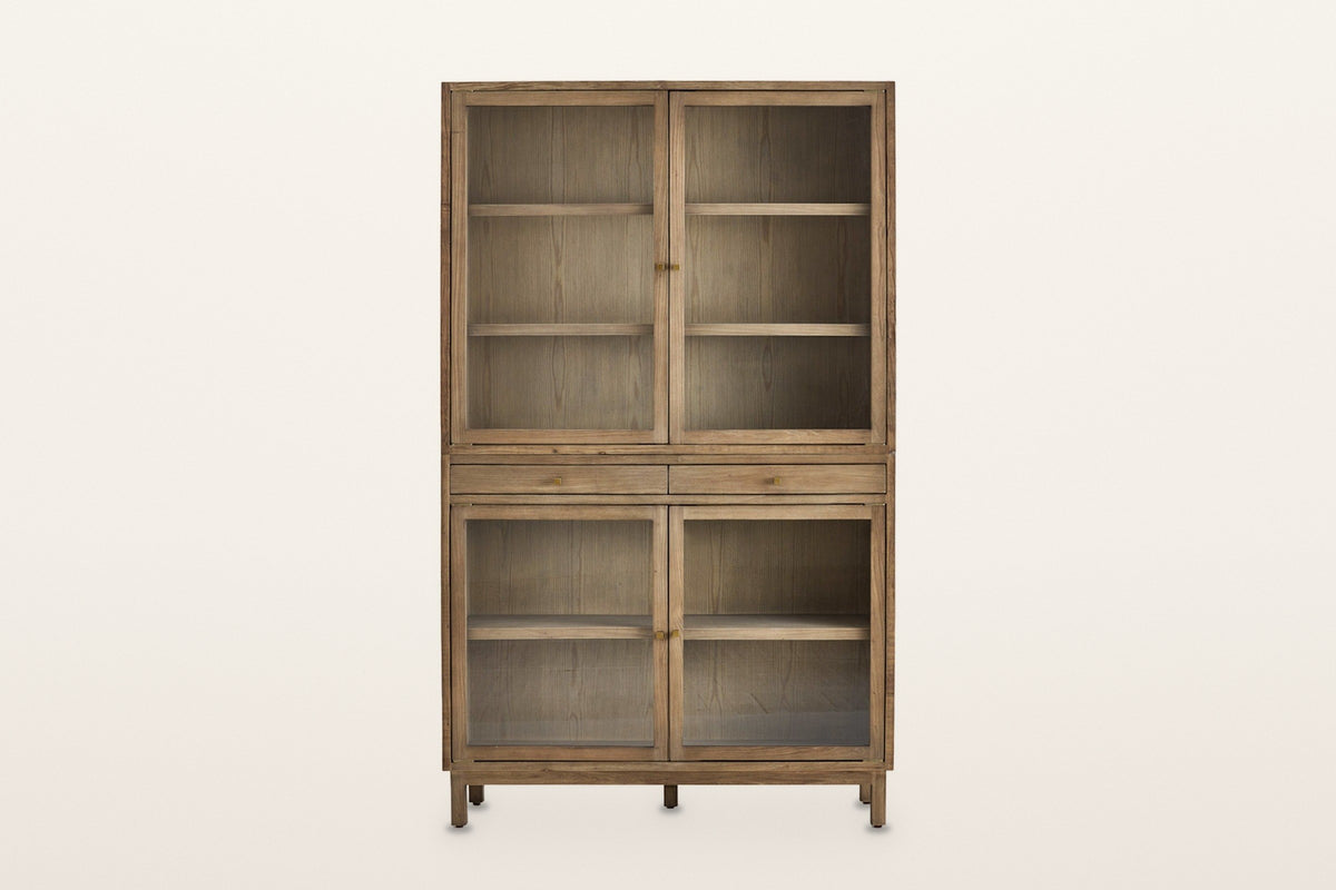 Suvereto display cabinet in Smokey Grey, straight front view on a warm white studio backdrop: single glass panes