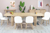 Sylvan dining table extended with six white chairs in a bright dining room