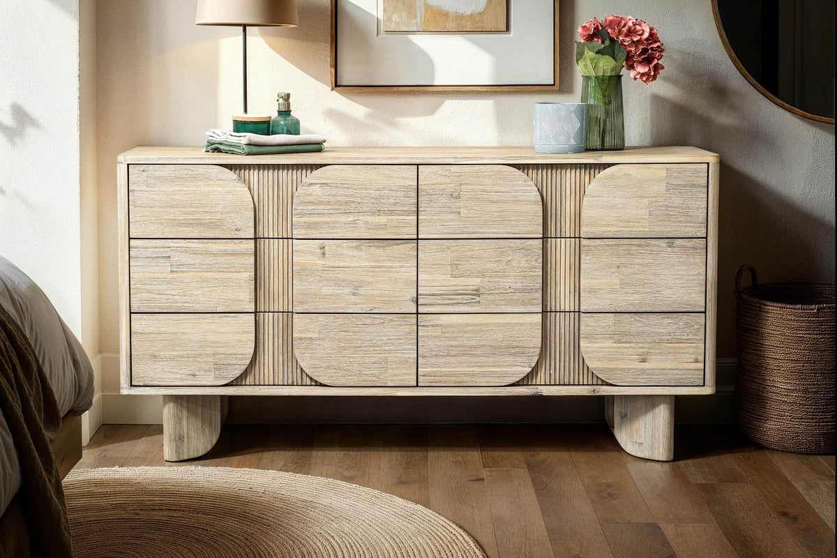 Sylvan dresser with a table lamp and flowers in a softly lit bedroom