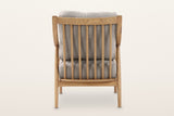 Tagliacozzo accent chair from behind on a warm white studio backdrop: seven ash spindles and the back cushion