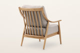 Tagliacozzo accent chair from the rear three-quarter on a warm white studio backdrop: seven spindles under one curved top rai