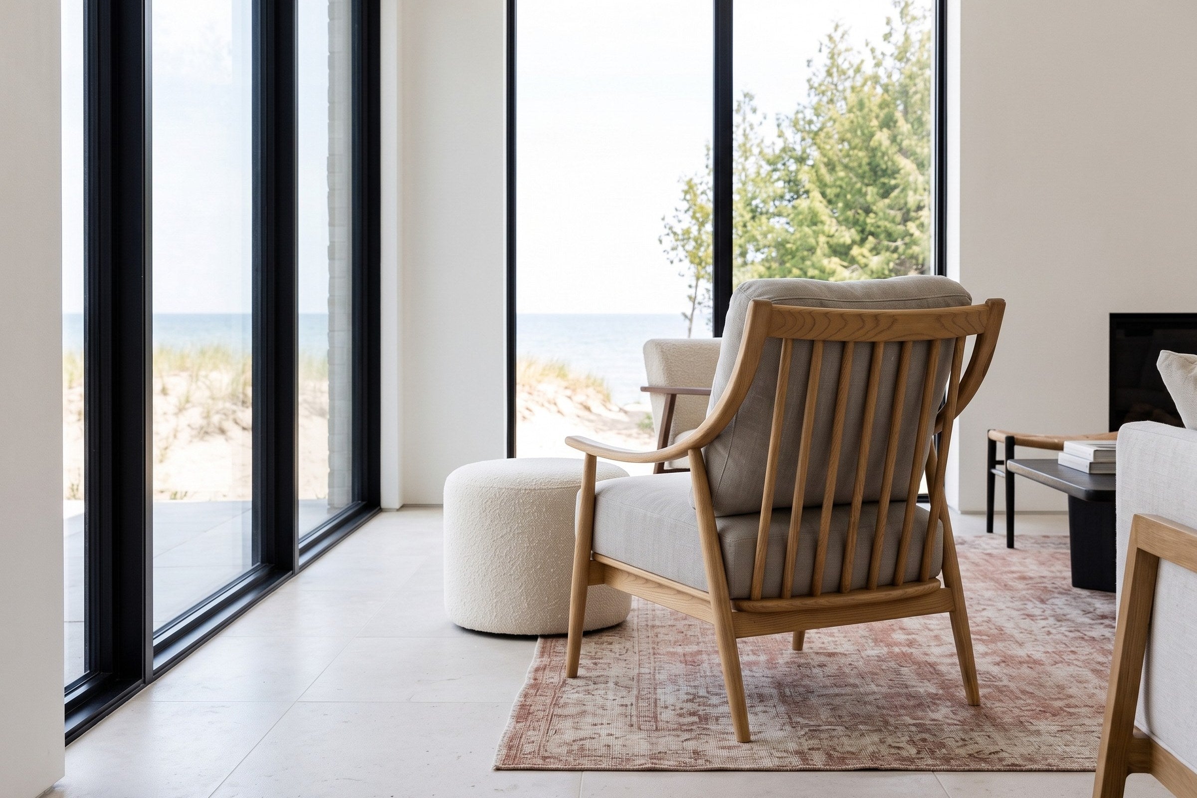 Tagliacozzo accent chair seen from behind in a Wellington lakeshore house, the ash spindles to the camera