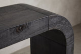 Close-up of a top corner: the rough-sawn black top, the hairline seam and the quarter-round bend