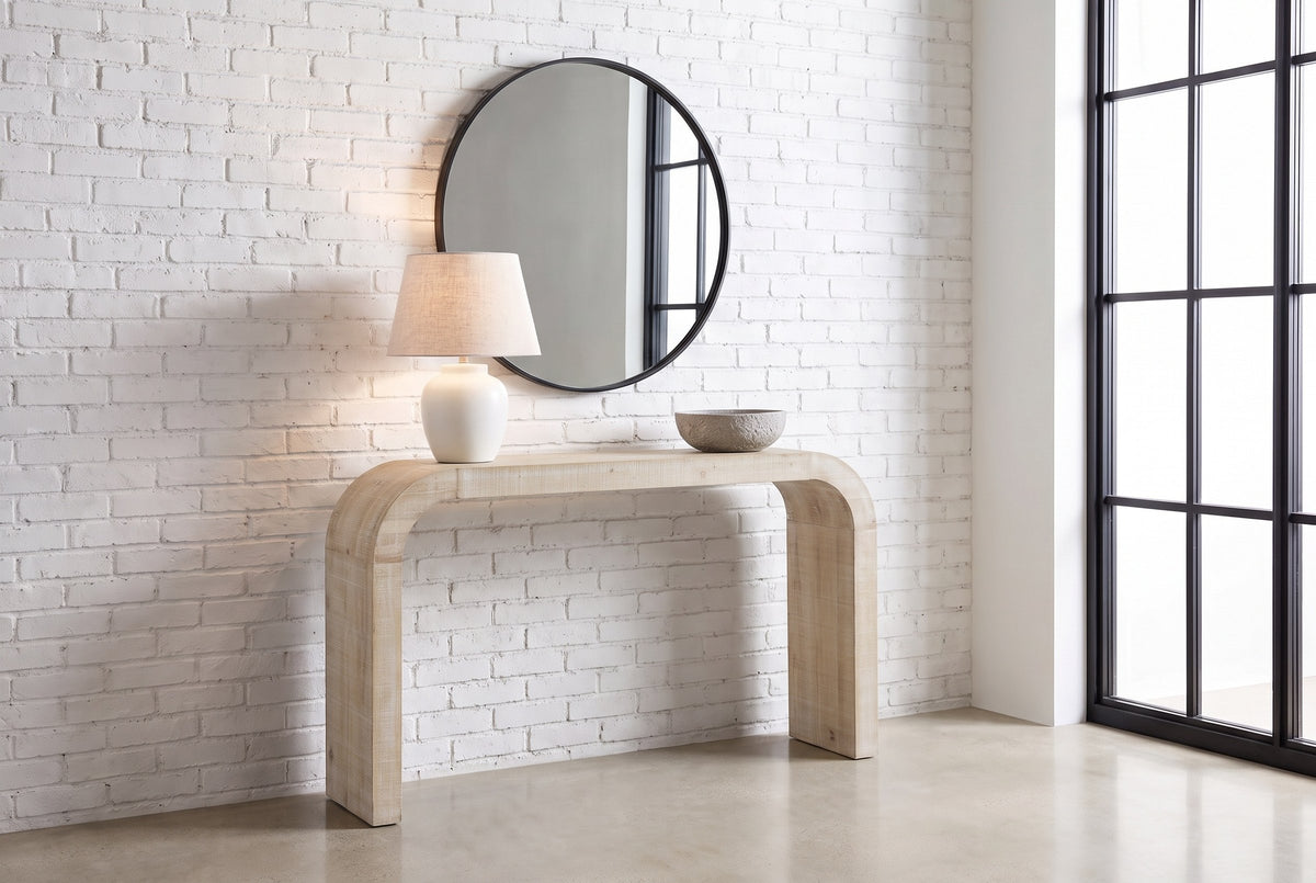 Tarvisio console table in natural in a Montreal loft entry, a white lamp and a stone bowl on top, a round mirror above