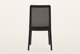Teggiano dining chair in Black from behind on a warm white studio backdrop: the woven cane panel in its black ash frame