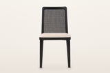 Teggiano dining chair in Black, straight front view on a warm white studio backdrop: the near-rectangular cane back with roun