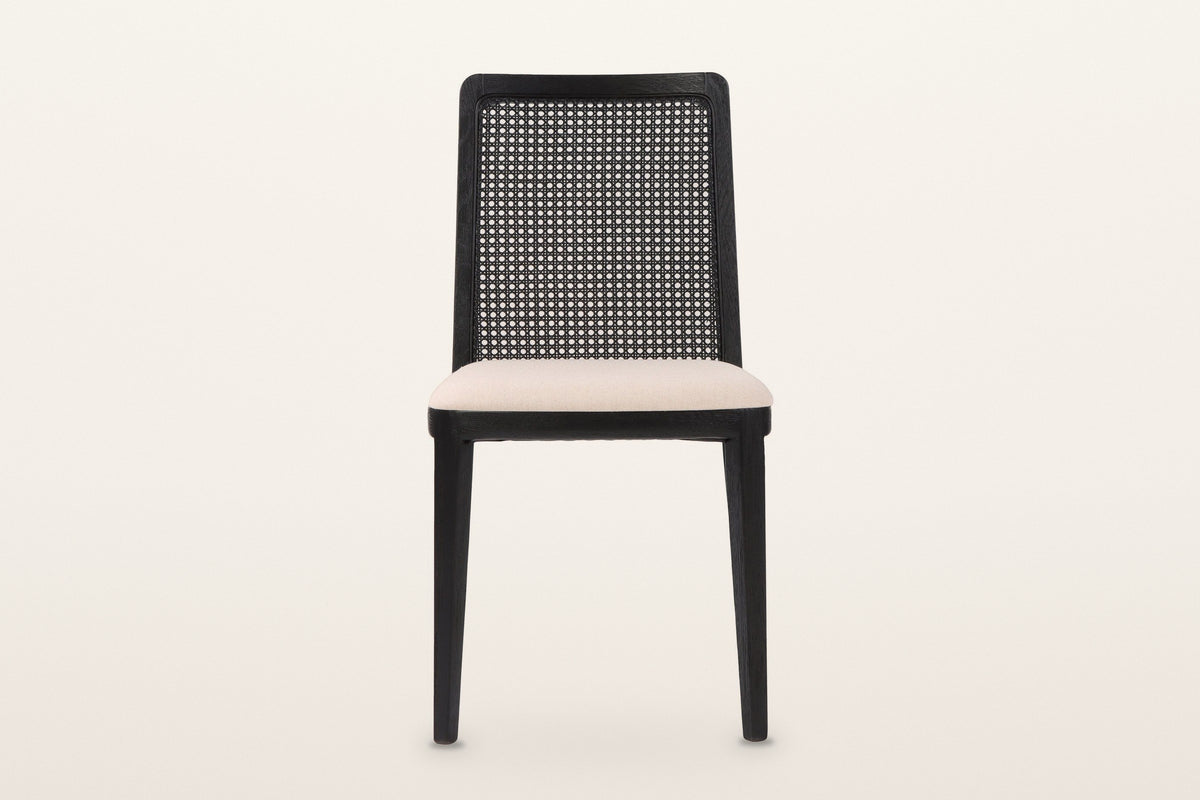 Teggiano dining chair in Black, straight front view on a warm white studio backdrop: the near-rectangular cane back with roun