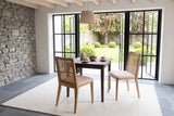 Two Teggiano dining chairs in Natural at a small square smoked-oak table in a Kinsale garden house, seen from above