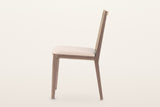 Teggiano dining chair in Natural, side view on a warm white studio backdrop