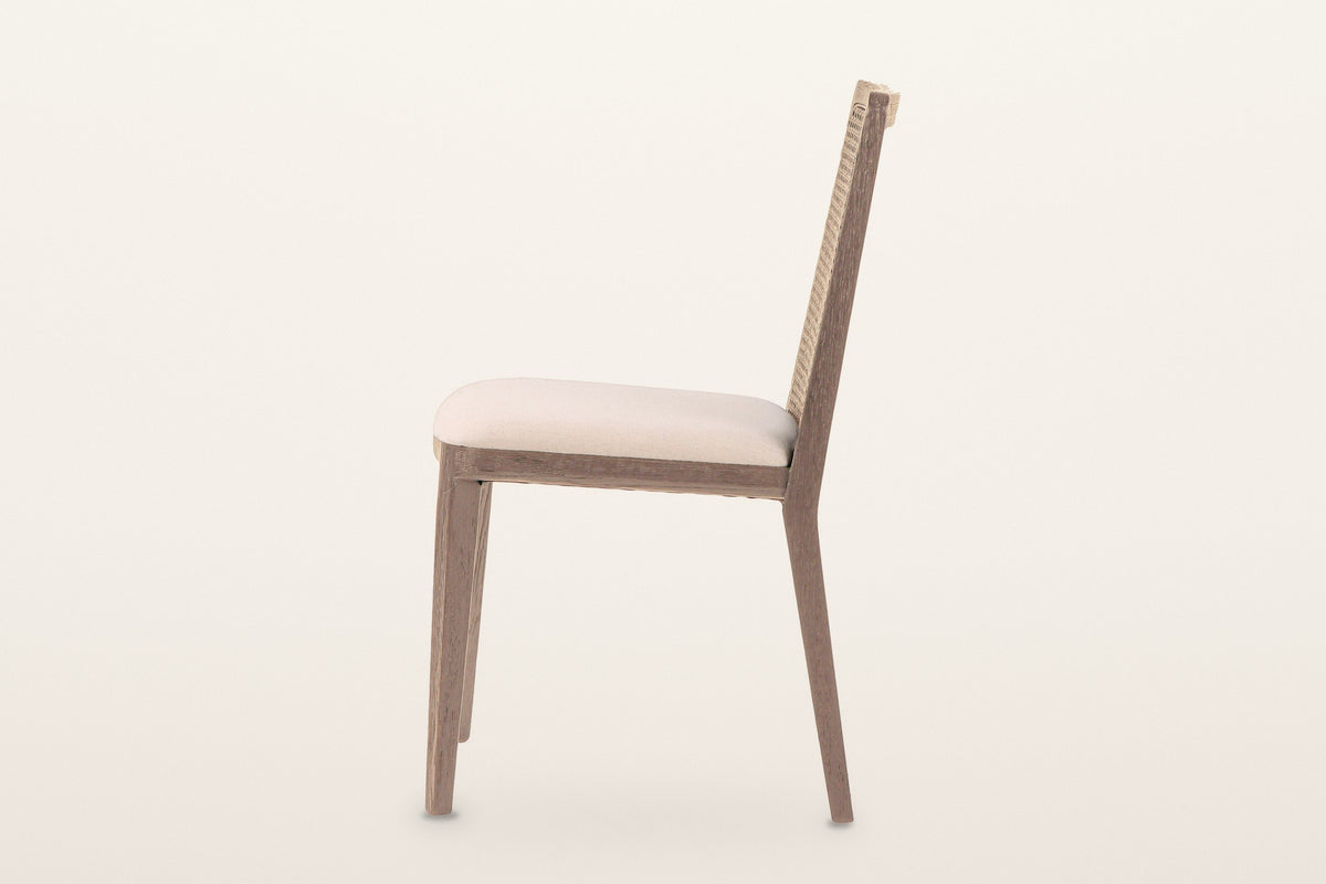 Teggiano dining chair in Natural, side view on a warm white studio backdrop