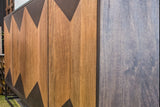 Close-up of the Tellaro door fronts in Walnut and Teak: honey mango panels and dark triangles meeting in sharp points