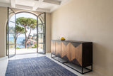 Tellaro sideboard in Walnut and Teak seen from the end along a sand plaster wall in a Lerici villa, with a coffered ceiling