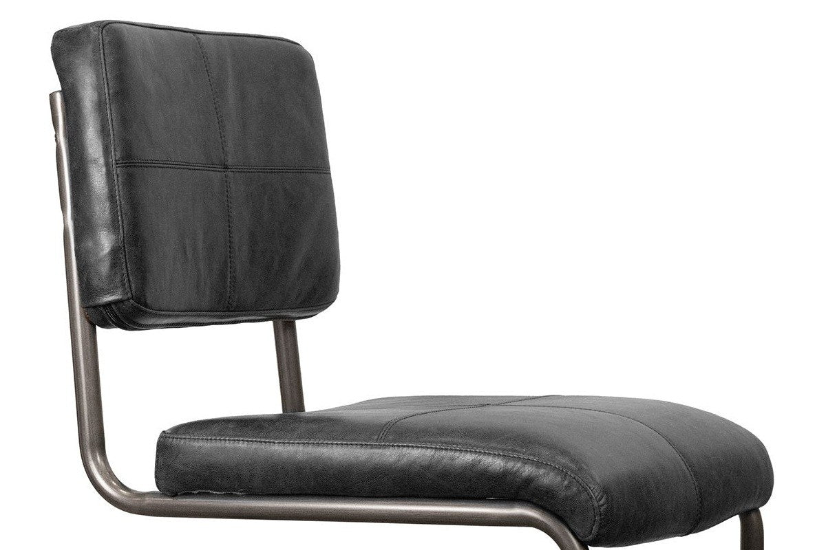 Close-up of the Tenno back and seat in black leather: the back stitched in four panels, the seat with a rolled front edge