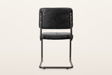 Back of the Tenno dining chair in Black on a warm white studio backdrop: the plain back of the cushion and the two posts