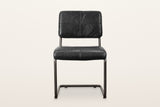 Tenno dining chair in Black, front view on a warm white studio backdrop: the back stitched in four panels and the thick seat