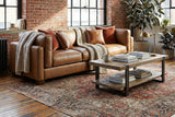 Thatcher Antique Sienna leather sofa in a brick-walled loft with a patterned rug