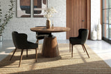 Thorne round acacia dining table with black chairs in a white brick room with tall windows