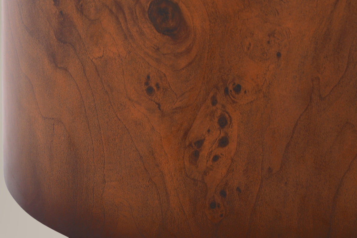 Close-up of the burl veneer finish on the side of a drum: wavy grain, a dark knot and clusters of small burl eyes
