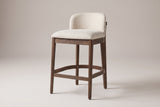 Torgiano counter stool in Walnut with a beige seat, three-quarter view on a warm light-grey studio backdrop