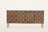 Trequanda sideboard in Brown, straight front view on a warm white studio backdrop: six rows of wide leather straps over and u