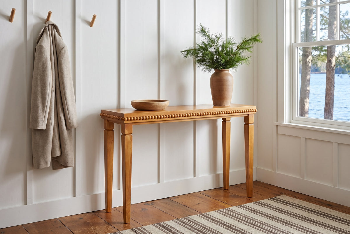 Treviso console table in a white board-and-batten Muskoka cottage entry, pine branches in a clay vase
