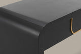 Close-up of the matte black top turning down through a soft rounded bend into the slab leg, the apron set back below it