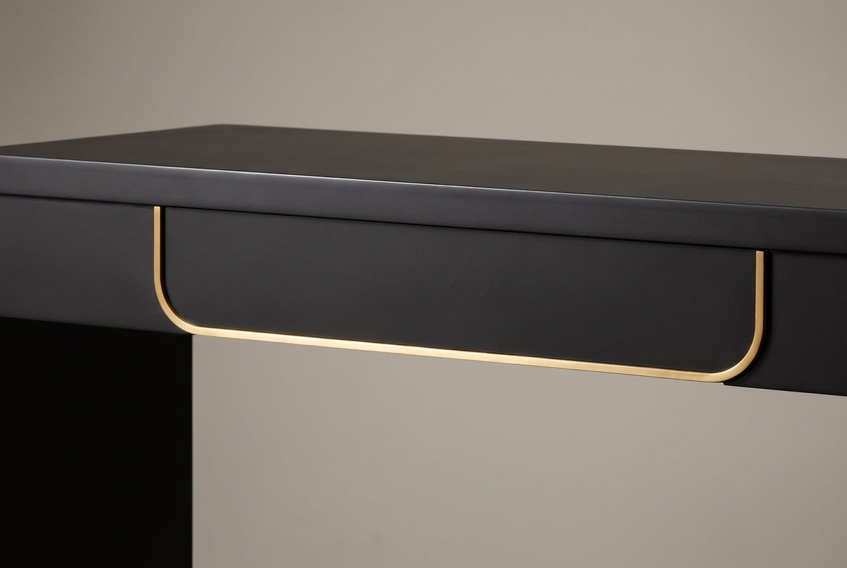 Close-up of the single drawer: a plain black front edged down both sides and along the bottom by a thin gold-tone band